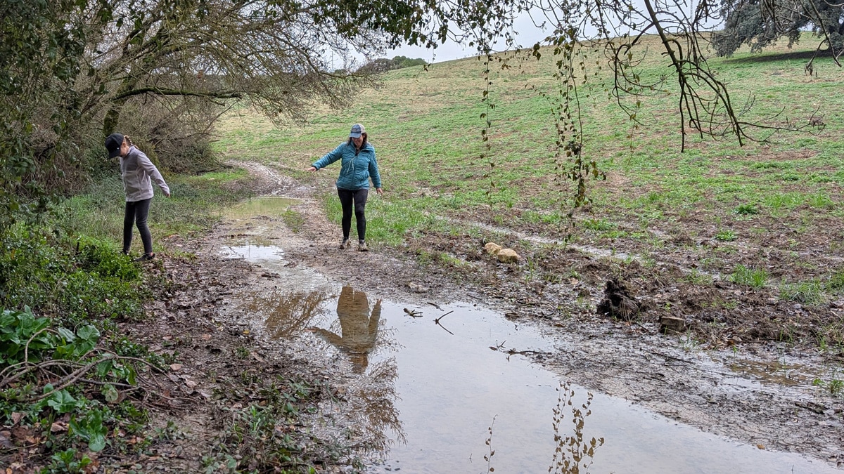 Lucía blogueraviajera caminando por el barro cerca el fuente de los 100 caños