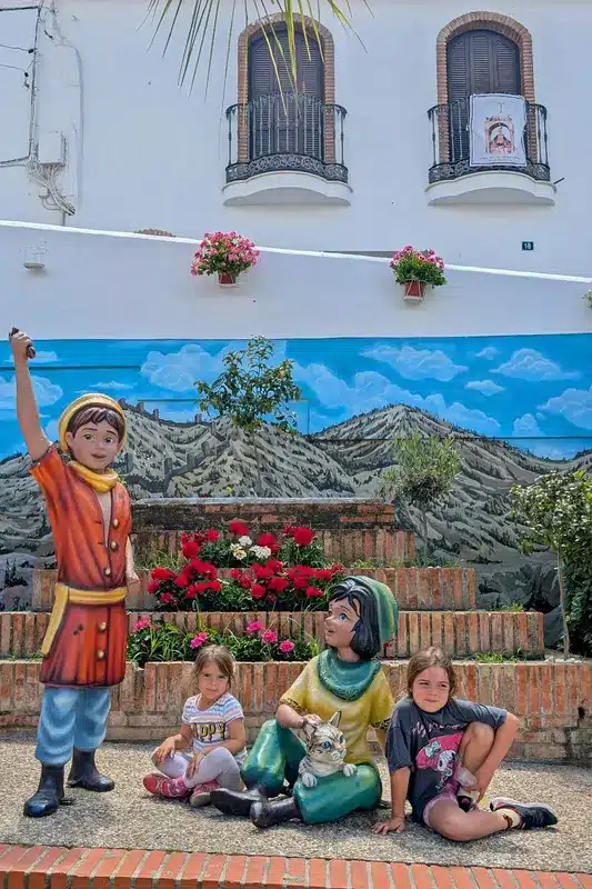 Cártama con niños: una escapada familiar cerquita de Málaga que te sorprenderá 12 Niñas junto a esculturas de Jarifa rodeadas de flores y murales en Cártama con niños