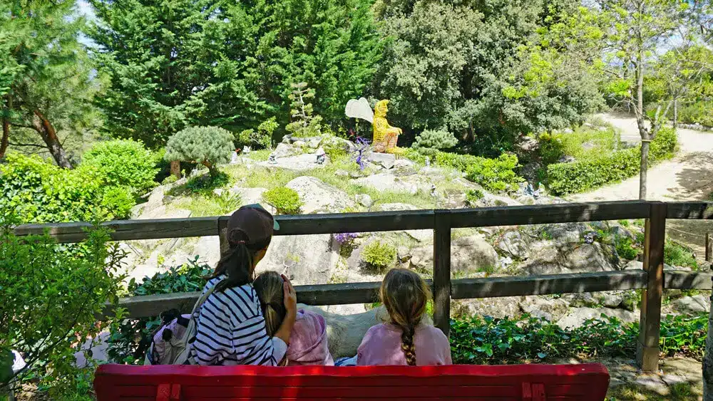 El Bosque Encantado de Madrid: una aventura en familia cerca de Madrid 8 Vista desde banco rojo hacia escultura mágica en El Bosque Encantado de Madrid en San Martín de Valdeiglesias