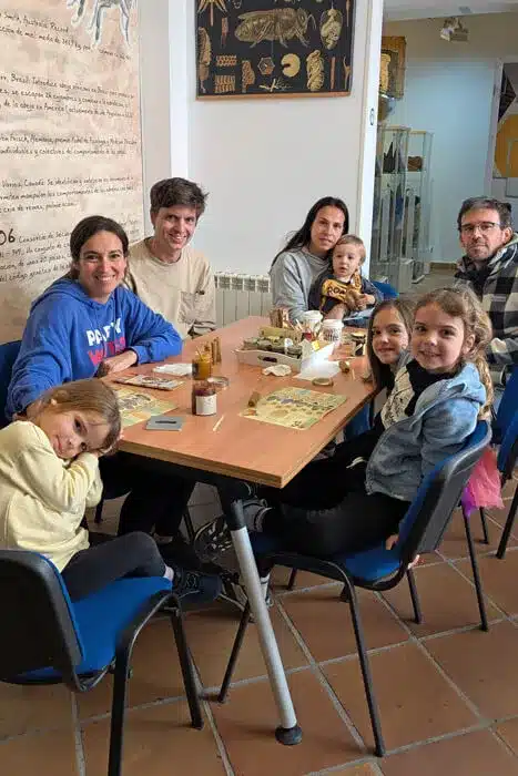 El Museo de la Miel de Colmenar: una dulce aventura en familia 6 Familia sentada en mesa educativa de taller de miel en el Museo de la Miel