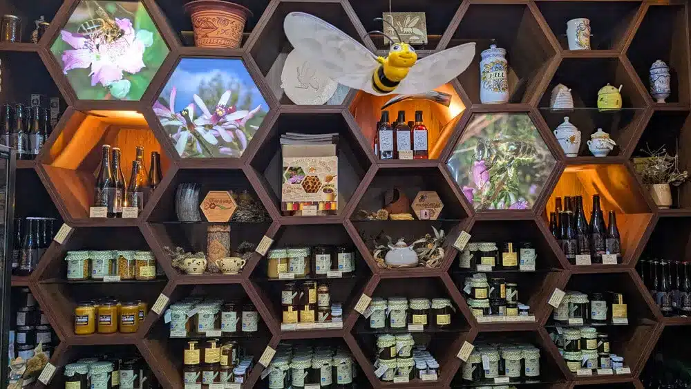El Museo de la Miel de Colmenar: una dulce aventura en familia 7 Productos locales y miel expuestos en estanterías hexagonales de la tienda del Museo de la Miel