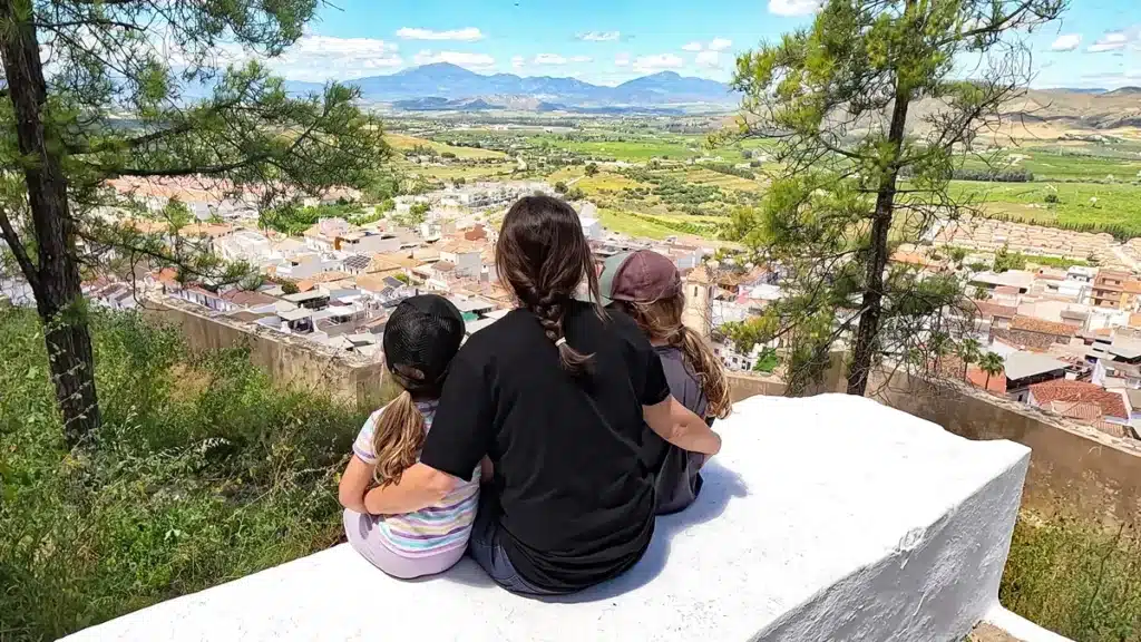 Cártama con niños: una escapada familiar cerquita de Málaga que te sorprenderá 7 Familia blogueraviajera contemplando el valle desde un mirador con vistas en Cártama con niños