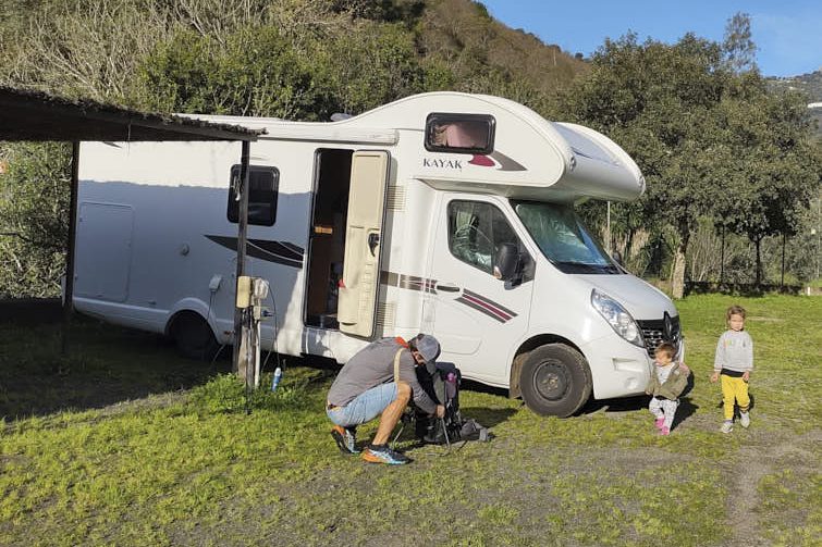 Autocaravana en un camping y Mike, África y Zoe al lado