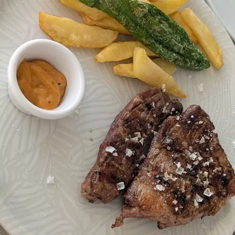 Qué ver en Fuente de Piedra: naturaleza, flamencos y planes curiosos 18 Plato de carne a la parrilla con patatas en la taberna de Joaquín en Fuente de Piedra