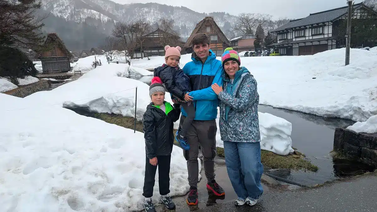 Alquilar coche en Japón: nuestra experiencia 2 Familia viajera disfrutando de la nieve en Japón durante una ruta en coche de invierno.