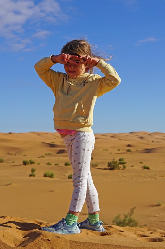 Niña en dunas del desierto Marruecos con niños