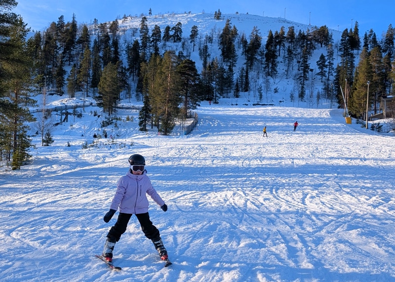 Esquiar en Finlandia una niña bajando una pista en la estación de Pyhä en Laponia