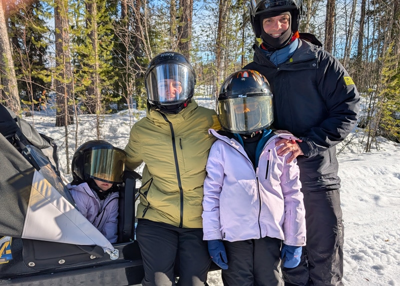 Familia disfrutando de motos de nieve en Laponia