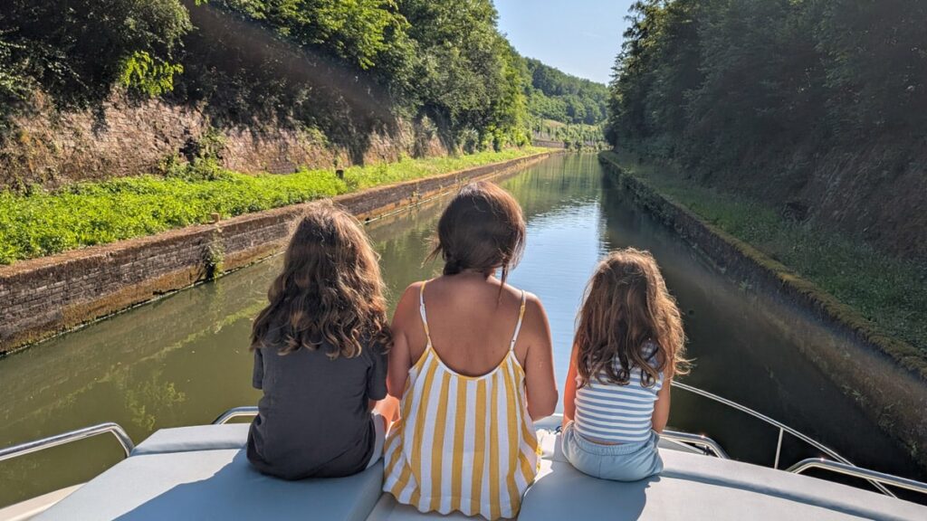 Las niñas en conversación con mama durante el crucero fluvial en Alsacia, Francia