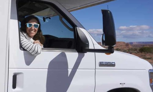 Lucía sonriendo asomada por la venta del copiloto de la caravana