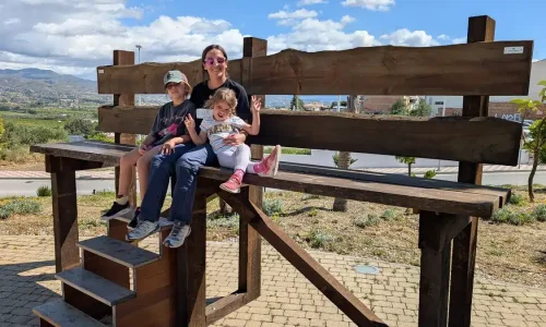 Familia disfrutando en un banco gigante con impresionantes vistas en Cártama con niños