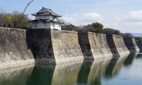 Vista panorámica del castillo de Osaka con su foso reflejando las murallas