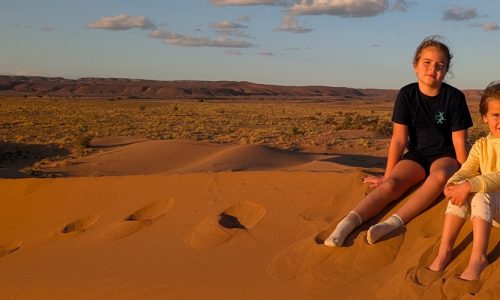 Niñas sentadas en la arena del desierto. Marruecos en familia