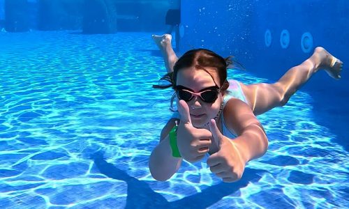 niña bajo la agua en una piscina