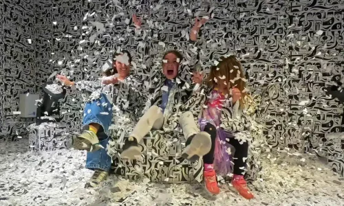 Sala de Ikono Madrid con niños cubierta de confeti y patrones gráficos en blanco y negro.